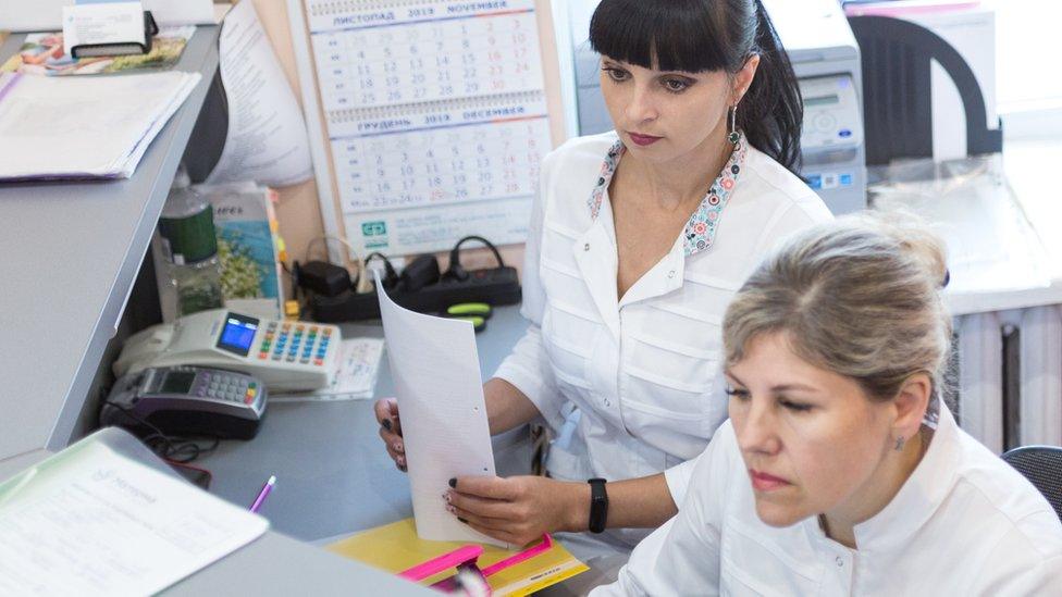 GP receptionists looking at computer