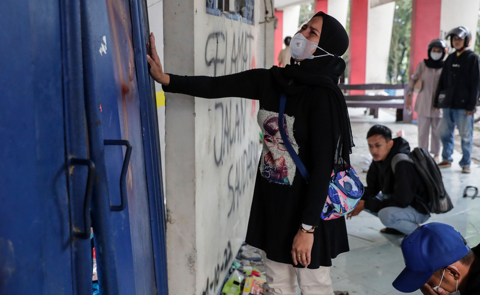 A woman weeps as she pay condolence to the victims of the soccer match riot and stampede at Kanjuruhan Stadium in Malang, East Java