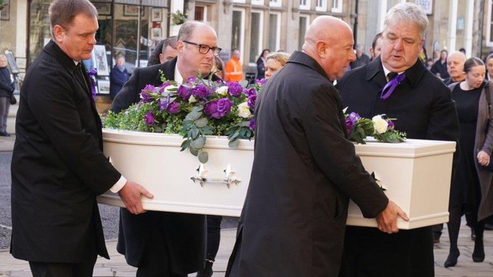 Holly's coffin being carried