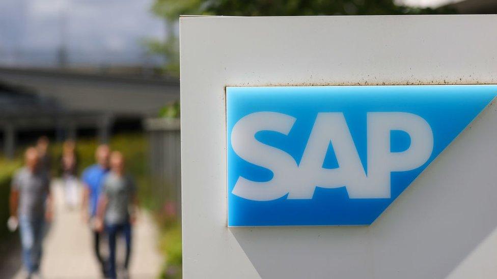 Employees near a logo at the SAP SE campus in Walldorf, Germany, on Thursday, July 15, 2021.