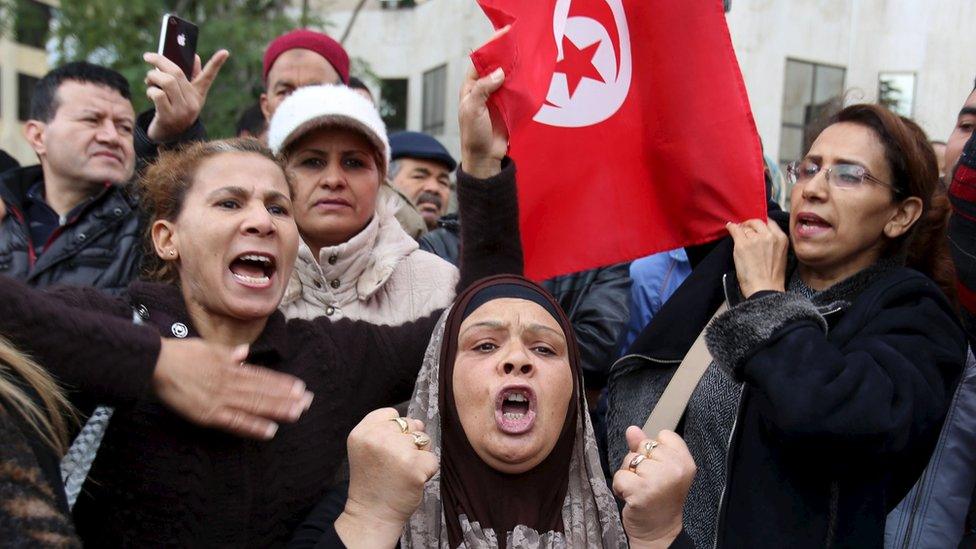 People shout slogans at a protest to condemn a suicide bomb attack in Tunis