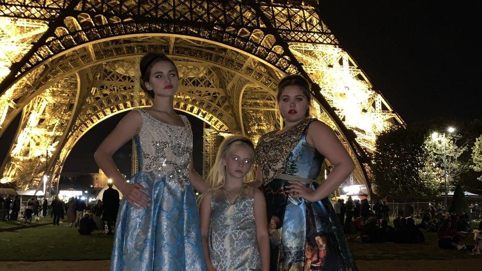 Daisy-May Demetre flanked by models in front of the Eiffel Tower