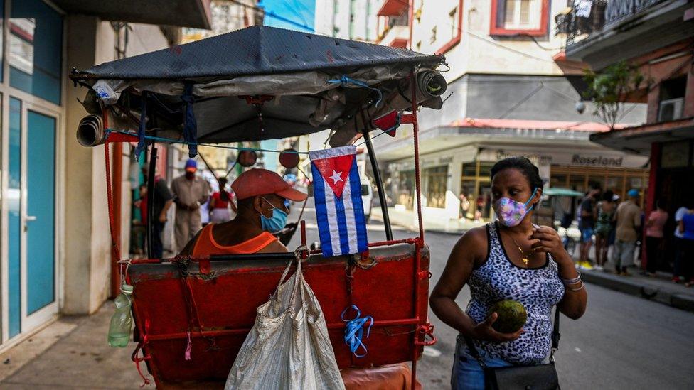 A woman looks at a rickshaw on a street in Havana, on 17 November 2021