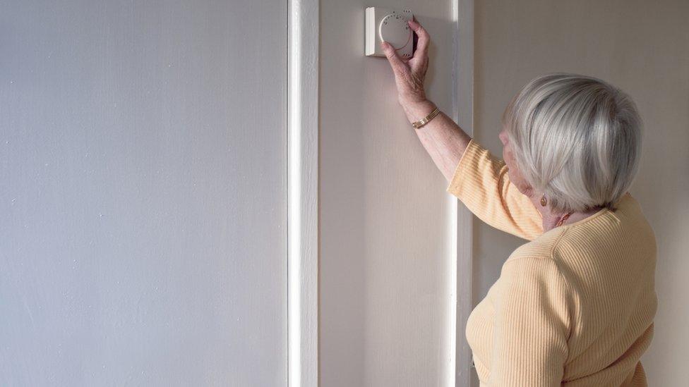 pensioner adjusting thermostat