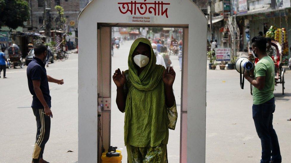 A Bangladeshi woman walks through a sanitization tunnel in Dhaka