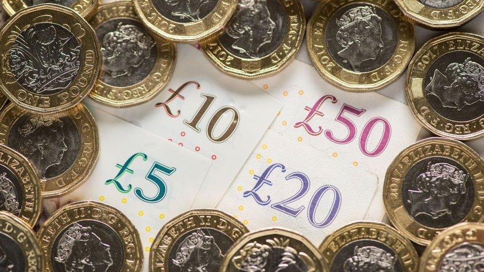 Pound coins surrounding notes in various denominations