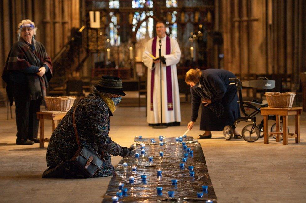 People light candles on the floor of Lichfield Cathedral