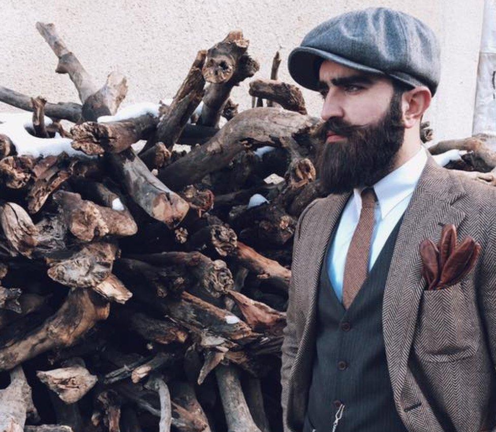 Iraqi man posing in a suit and cap