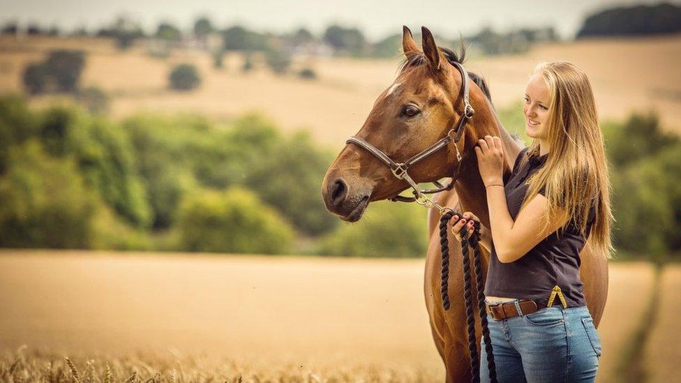 Gracie Spinks in a field with a horse