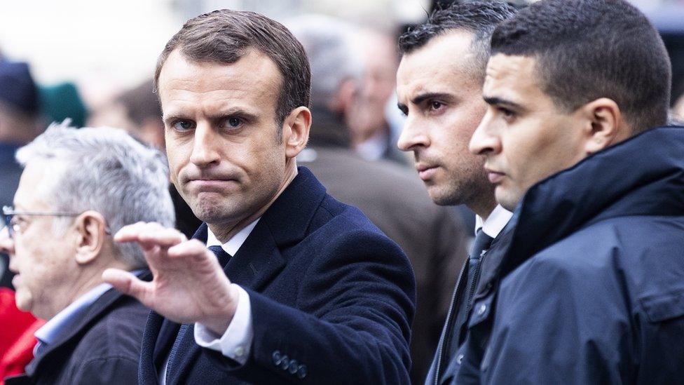 Mr Macron inspecting the damage in Paris caused by the protests.