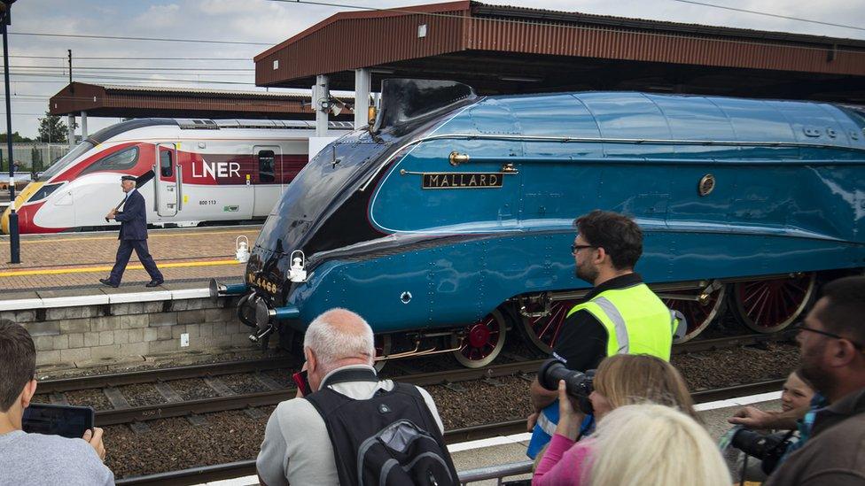 Mallard steam locomotive being photographed by people