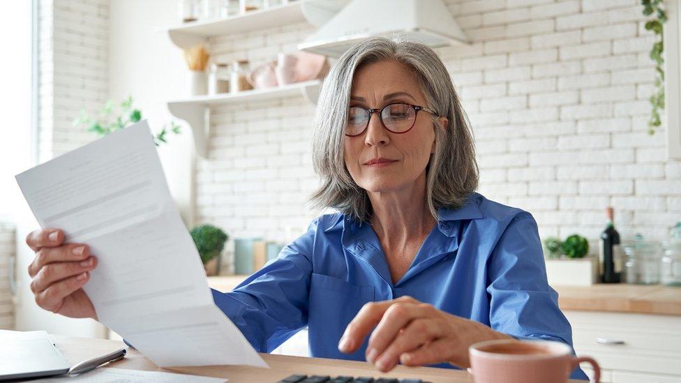 Woman looking at bill (stock image)