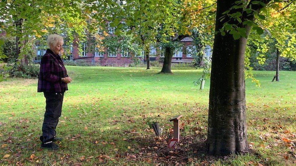 Christine looking at her sister's grave