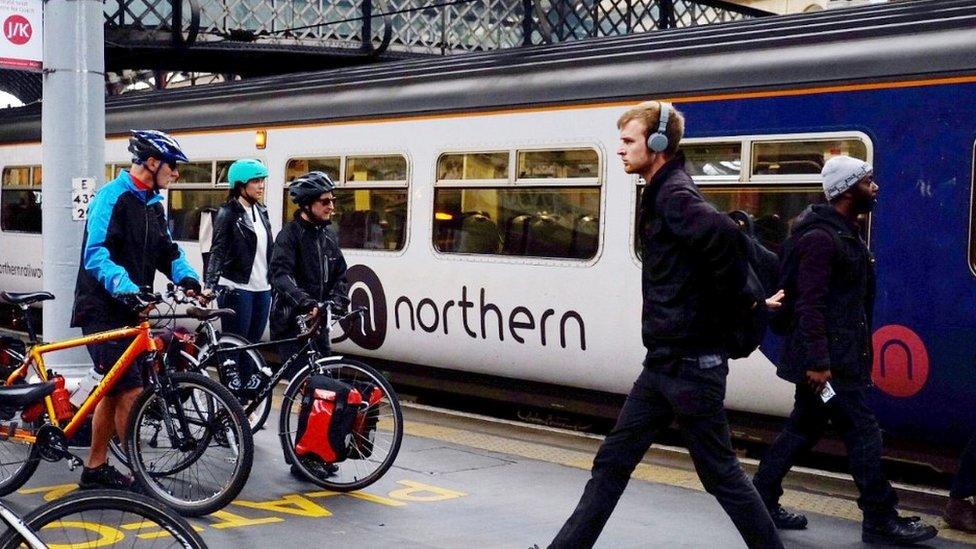 commuters on platform next to northern train