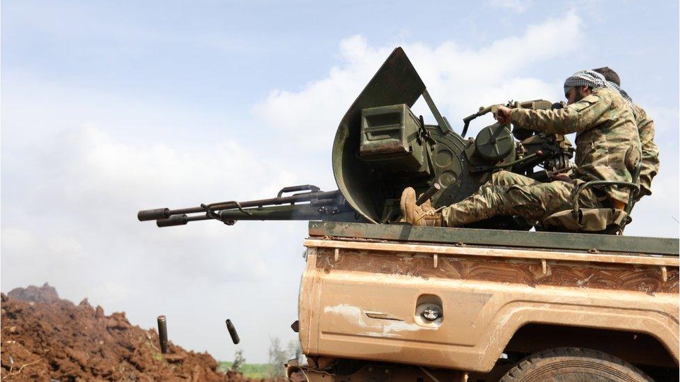 Turkish-backed Syrian opposition fighters fire an anti-aircraft gun during battles with Kurdish fighters in the region of Afrin