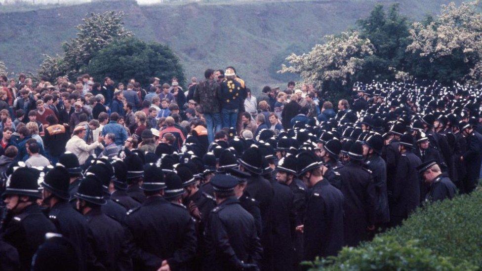 Ranks of police watch striking miners