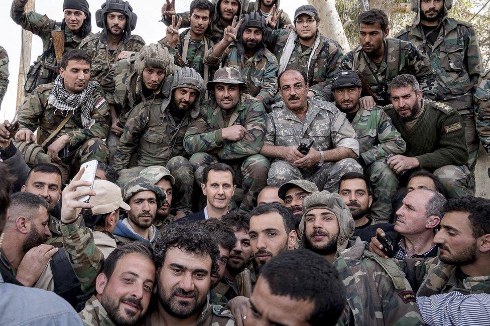 Syrian President Bashar al-Assad poses for photos with soldiers near the frontline in the Eastern Ghouta on 18 March 2018