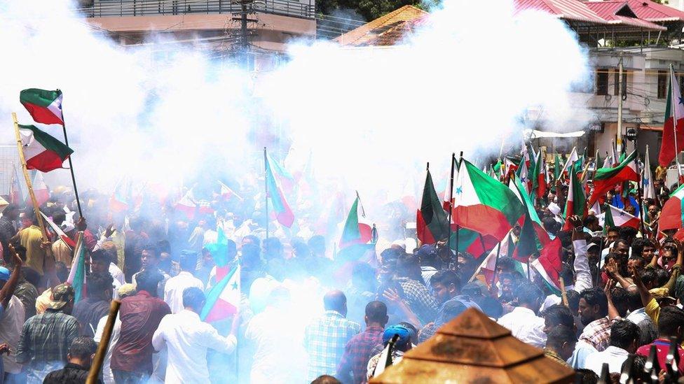 Police use tear gas to disperse members and activists of the Popular Front of India (PFI) during a demonstration to protest against what they say is police targeting its leaders