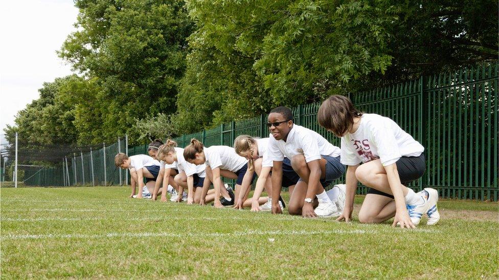 School children on a school field prepare to race