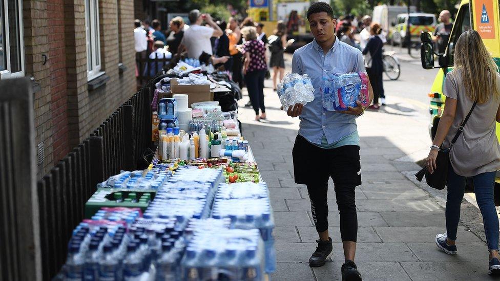 A man donates water to survivors of the fire