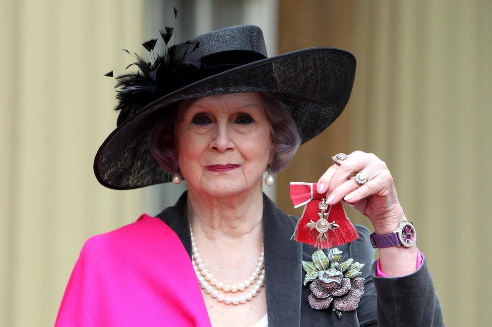 April Ashley poses with her Member of the British Empire (MBE) medal at Buckingham Palace in central London on December 13, 2012