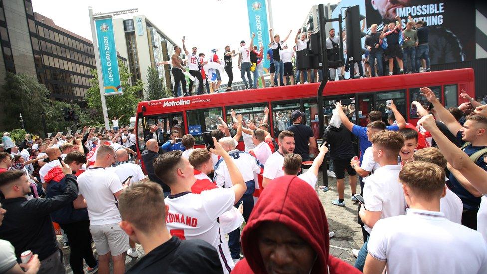 Fans climb on a bus near Wembley stadium