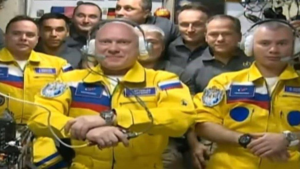 Image taken from live feed shows the cosmonauts in yellow suits