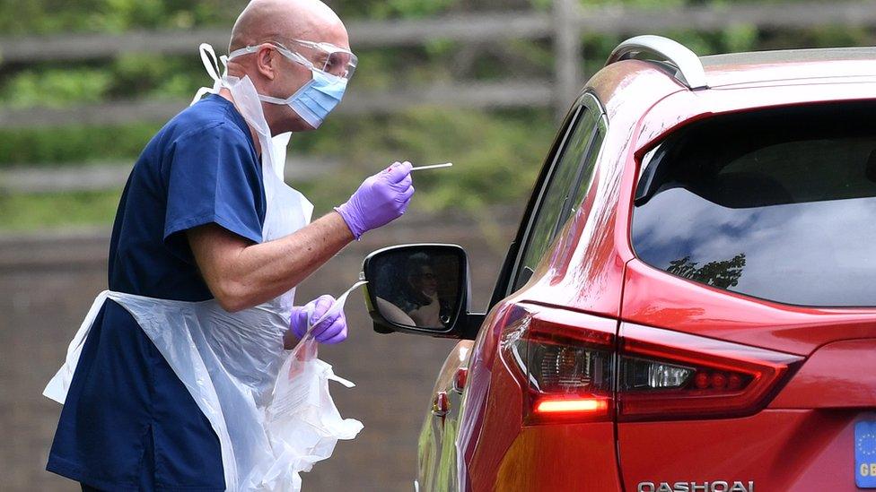 A medical professional tests an NHS worker at a testing facility at a McDonald's Drive-Thru in Leicester on April 25, 2020.