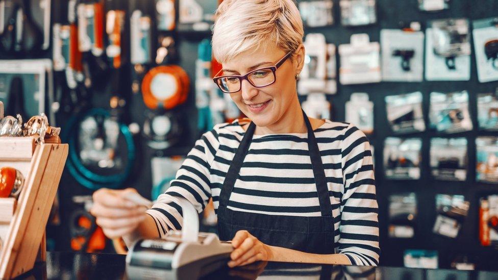 Woman taking a payment in a shop