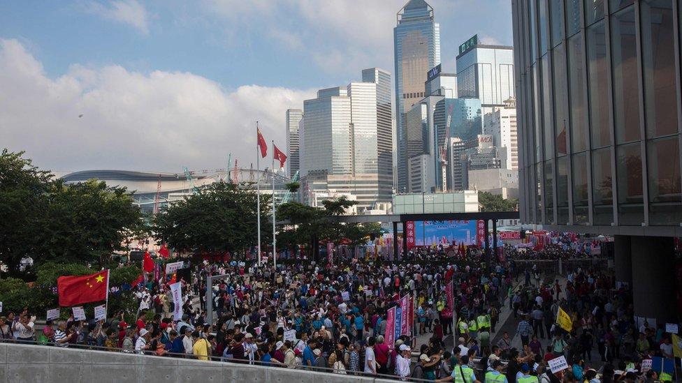 Pro-Beijing demonstrators gather outside the Hong Kong Legislative Council on November 13, 2016, during a rally in support of an interpretation of the city"s constitution - the Basic Law - by China"s National People"s Congress Standing Committee (NPCSC), over the oath-taking attempts by newly elected lawmakers Baggio Leung and Yau Wai-ching at the Legislative Council last month