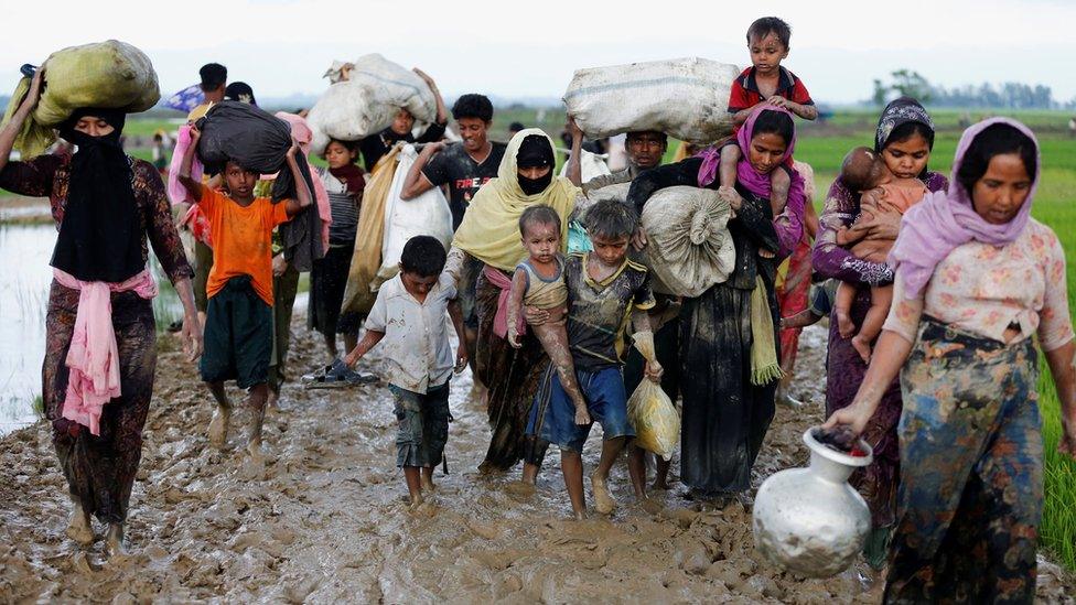 Rohingya refugees walk on the muddy road after travelling over the Bangladesh-Myanmar border, Teknaf, 2 Sept 2017