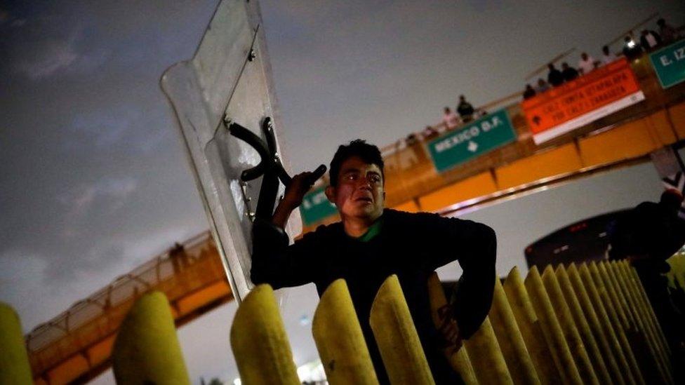 A migrant holds a shield as members of the migrant caravan clash with police, who are preventing them from passing on the Mexico-Puebla highway, in Los Reyes La Paz, Mexico, December 12, 2021.