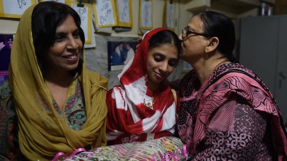 Bilquees Edhi (R) kisses deaf-mute Indian woman Geeta before leaving for the airport from the EDHI Foundation in Karachi on October 26, 2015.