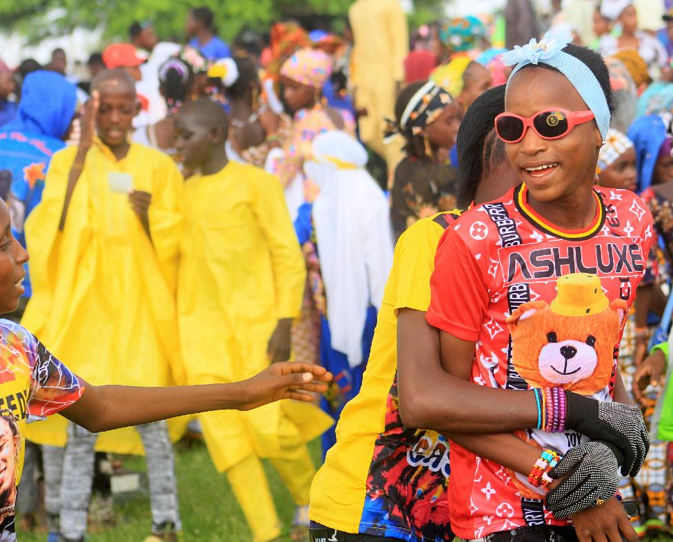 A smiling girl being hugged from behind
