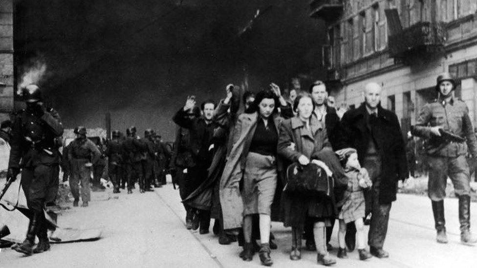 Nazi soldiers march Jews out of the ghetto on 19 April 1943