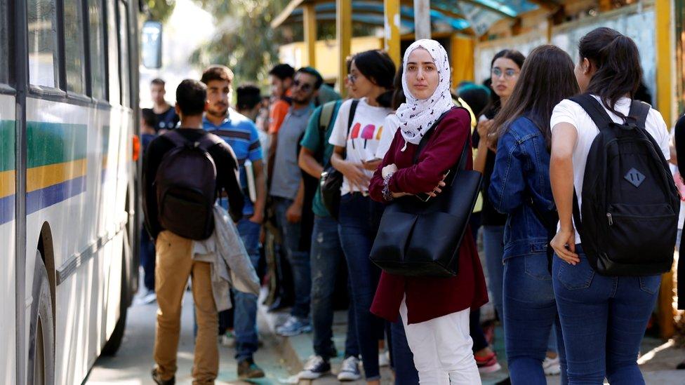 Youth people waiting for a bus outside Manar university in Tunis, Tunisia - October 2019