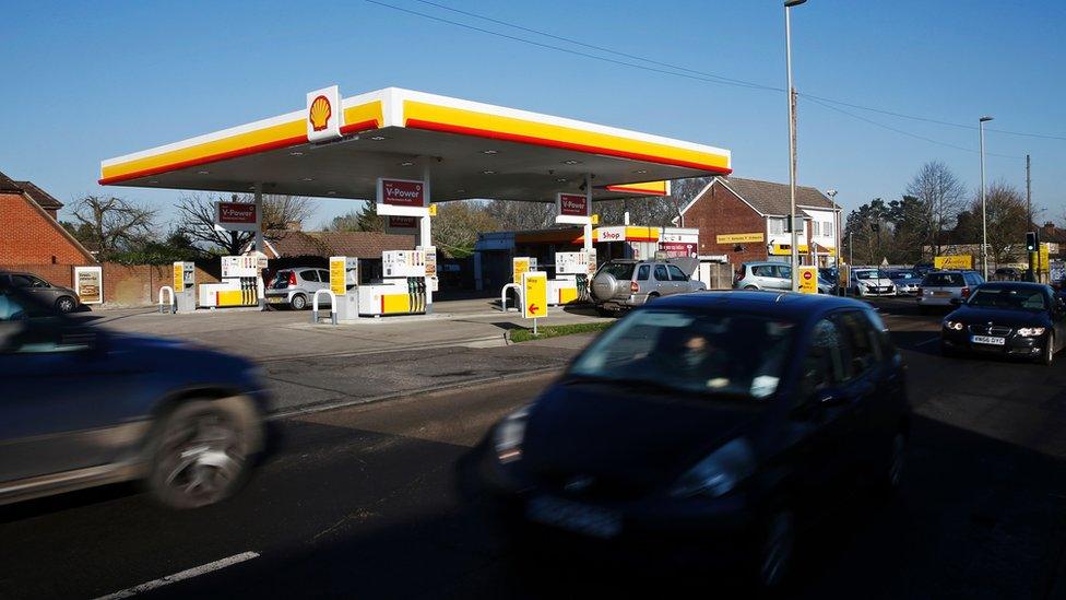 Cars drive past a Shell garage in the UK