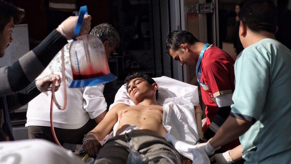 Turkish medics bring in a wounded man at Kilis State Hospital after an air strike in northern Syria (15 February 2016)