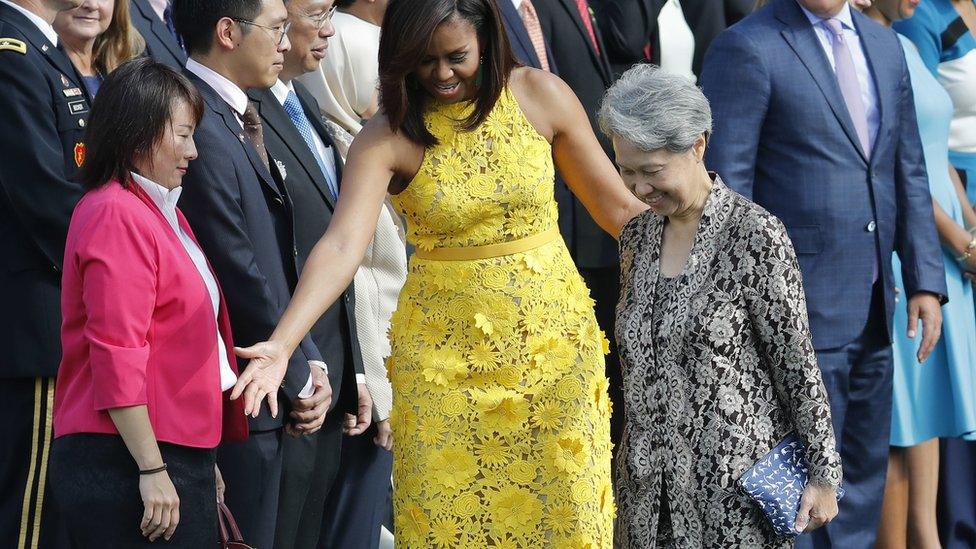 First lady Michelle Obama directs Ho Ching, right, wife of Singapore"s Prime Minister Lee Hsien Loong, where to stand during a state arrival ceremony on the South Lawn of the White House in Washington, Tuesday, Aug. 2, 2016