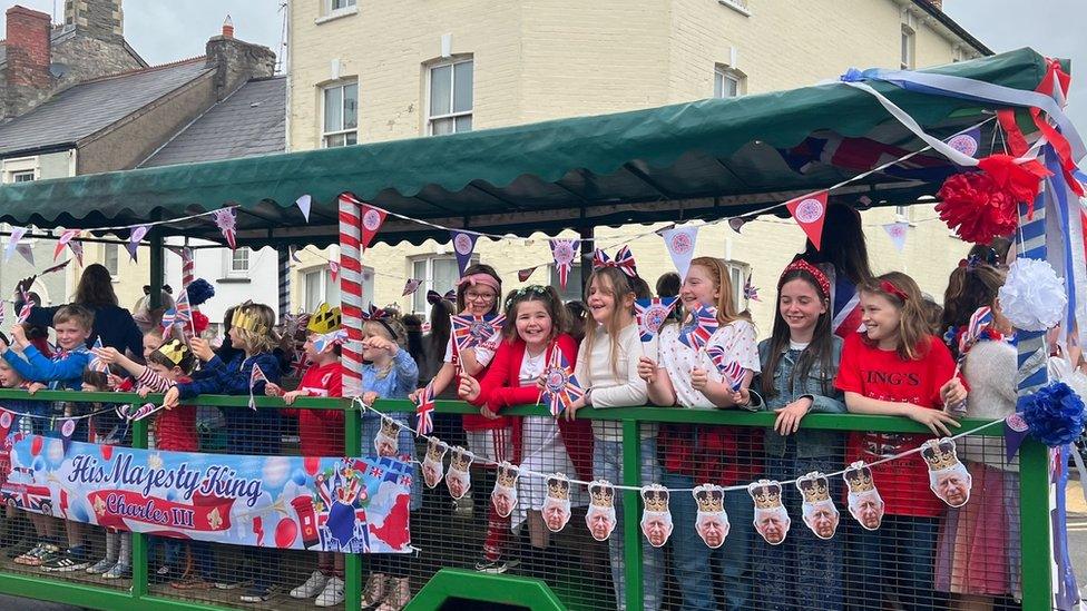 children on a carriage waving flags