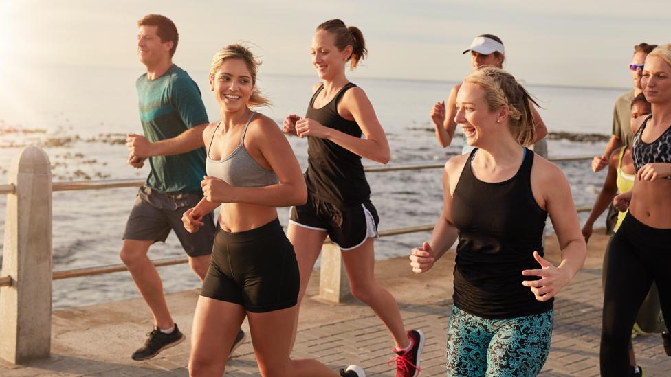 Healthy young people running along a seaside promenade