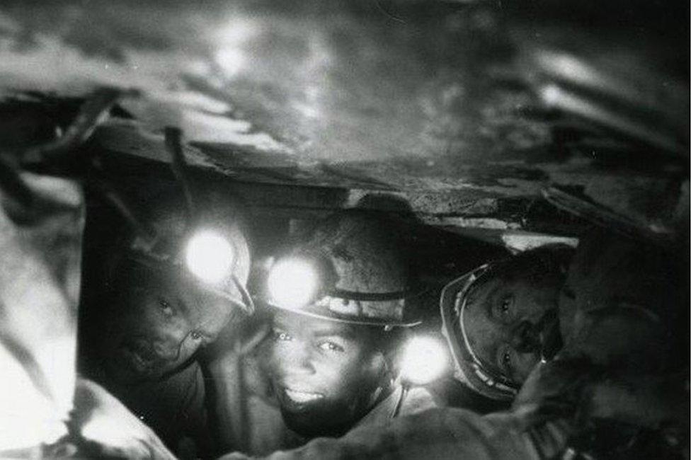 Three of the run men working under the chocks at the coal face at Gedling Colliery