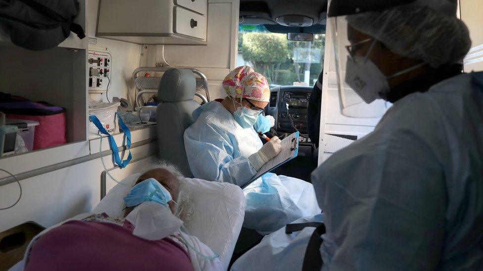 A nurse fills in a form on behalf of an elderly patient inside an ambulance in Sao Paulo, Brazil (2 July 2020)