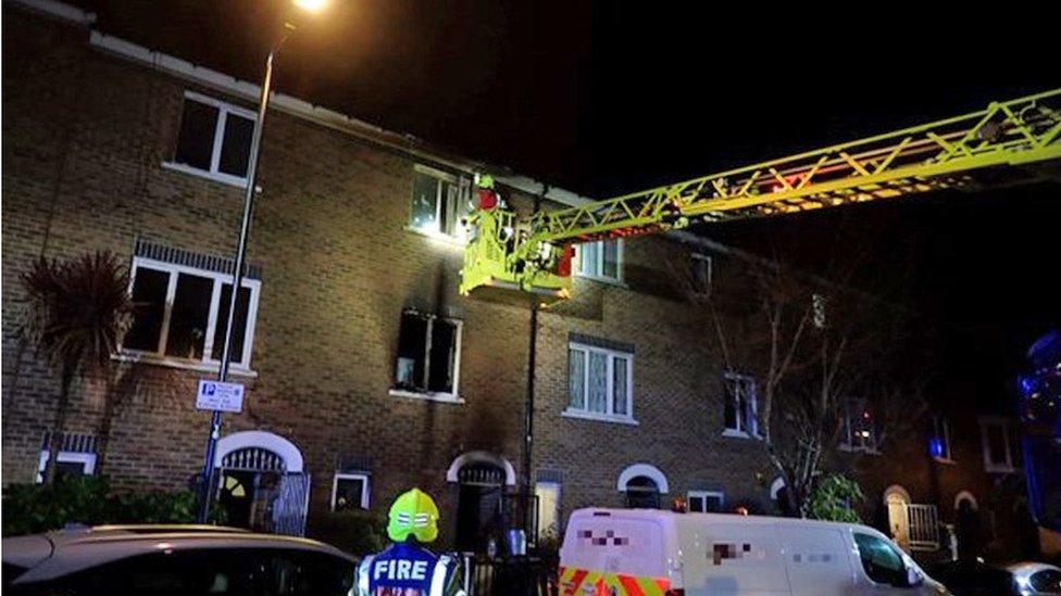 Firefighters accessing the house involved in the fire from the top floor