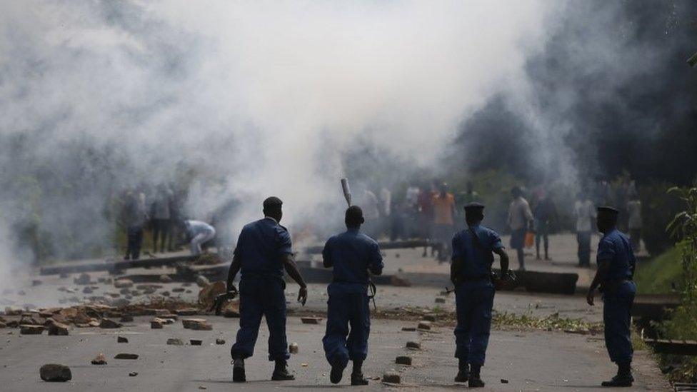 Police in front of tear gas plumes