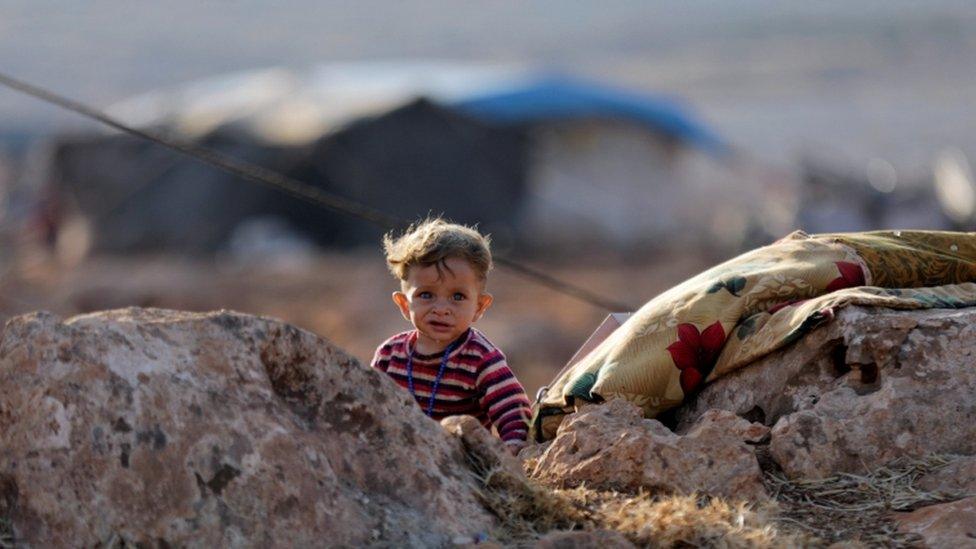 A newly displaced Syrian child near a refugee camp in Atimah village, Idlib province