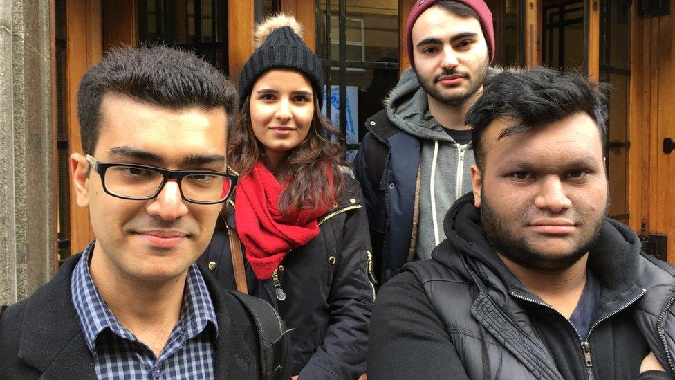 A group of shoppers pose in a shop doorway