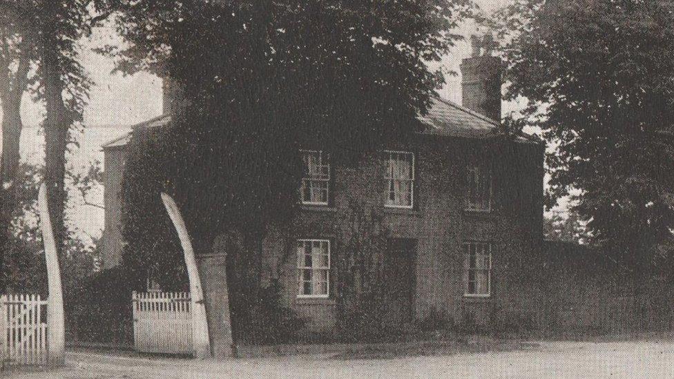 A historic photo of a gateway in March where two whale bones used to stand