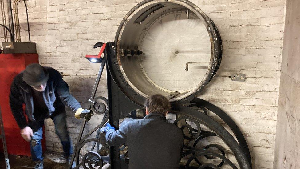 Repairers looking at clock parts