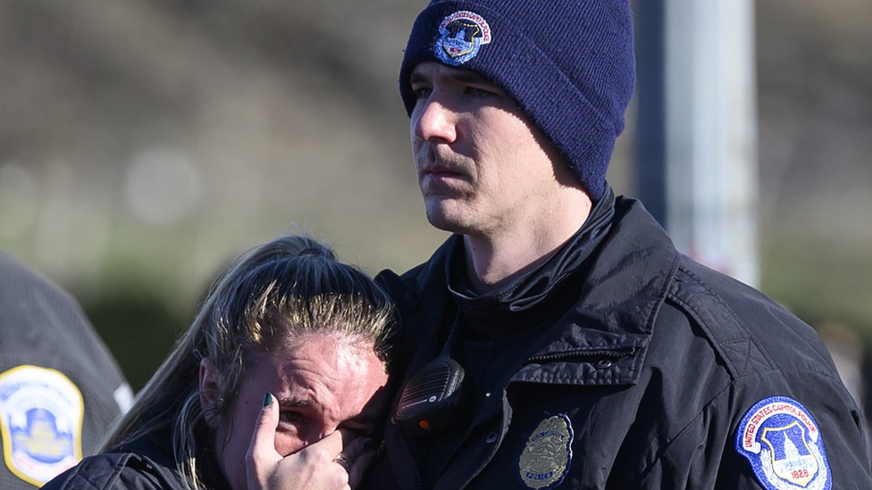 A male and female police officer mourn after the Capitol riot